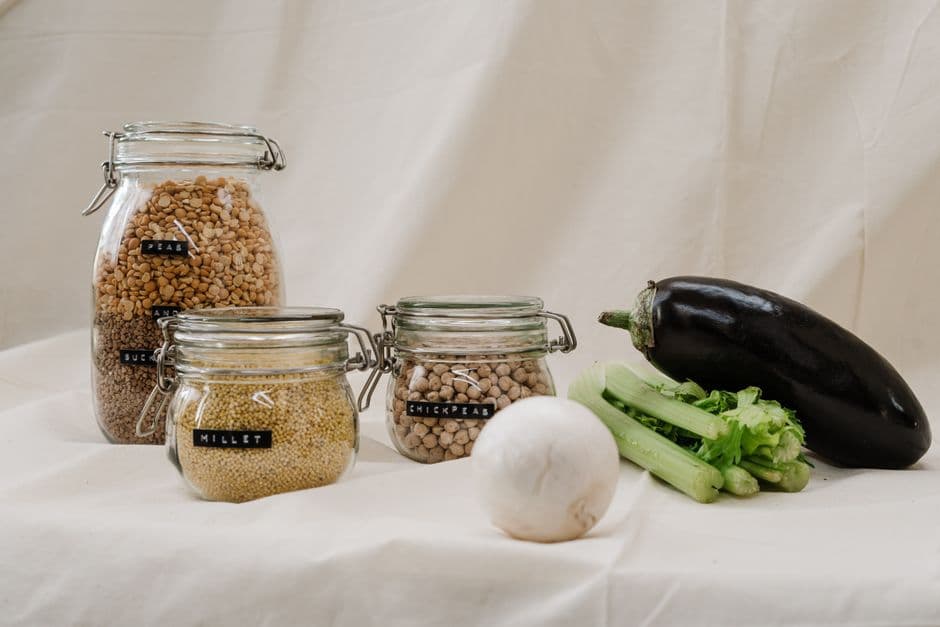 Whole food ingredients including chickpeas, millet and vegetables in jars and bowls, showing the variety of foods matched by the USDA FoodData Central nutrition database